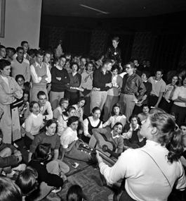 A group of students in 1956 sing, some playing guitars